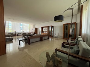 A spacious living area with a long wooden bench, a glass coffee table, and a modern floor lamp. - Hermoso Depto. en Playa Peninsula Nuevo Vallarta (Nuevo Vallarta)