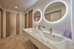 A bathroom with two sinks, wooden doors, and a large mirror with circular lighting. - eni suite macchamachi (Chuo-ku)
