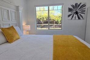 A bedroom with a bed, two pillows, a window, a lamp, and a wall art piece. - Luxury Escape | Heated Pool/Spa • Views + Events (Alpine)