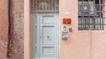 A door with a security keypad and a window with a metal grille.