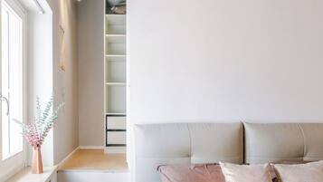 A bedroom with a bed, a nightstand, a window, and a built-in closet.