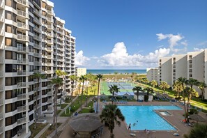 Een hotel met meerdere verdiepingen, een zwembad en uitzicht op het strand.