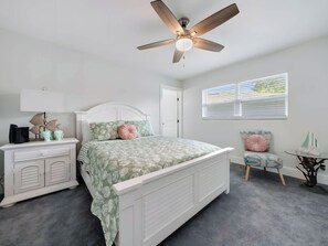 A bedroom with a bed, a nightstand, a chair, a ceiling fan, and a window with blinds. - Two-Story 3BR with Pool Table and Private Yard (St. Petersburg)