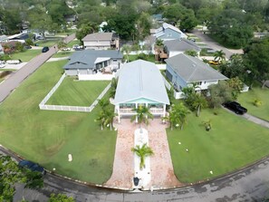 A residential area with multiple houses, a paved driveway, and a lawn. - Two-Story 3BR with Pool Table and Private Yard (St. Petersburg)