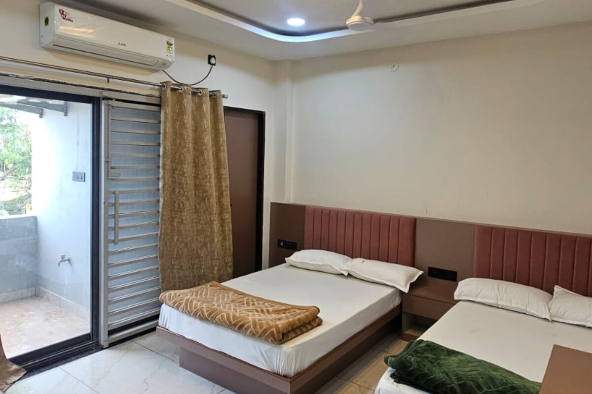 A hotel room with two beds, a ceiling fan, and an air conditioning unit.