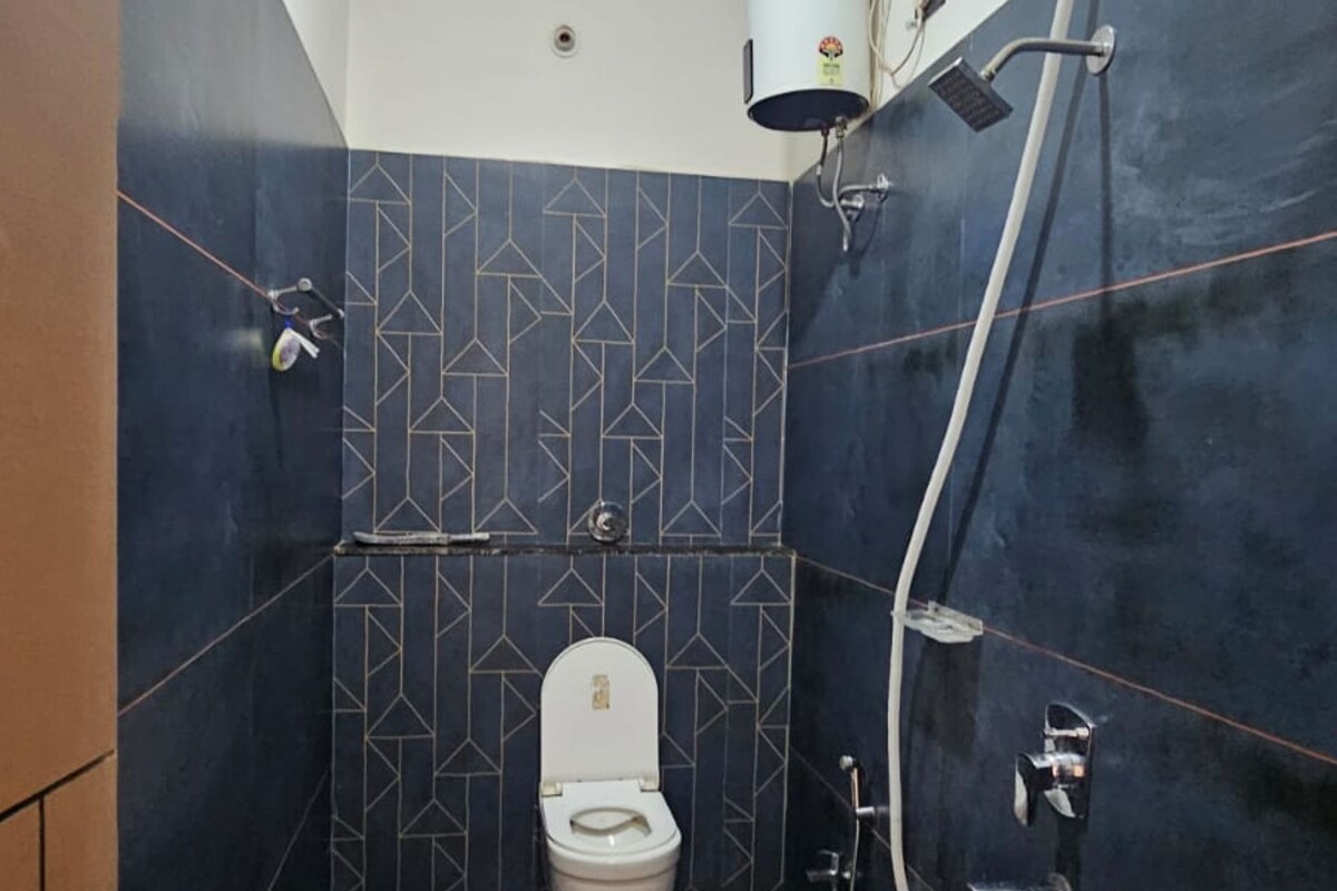 A small bathroom with a toilet, a shower, and a sink.