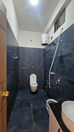 A small bathroom with a toilet, a shower, and a sink. - Hotel Mahakal Palace (Ujjain)