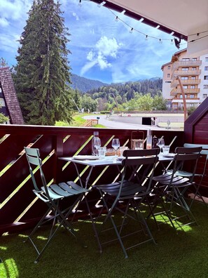 An outdoor dining area with a view of a mountain and forest. - Le Dahut Blanc, a charming retreat at the foot of the slopes (Morillon)