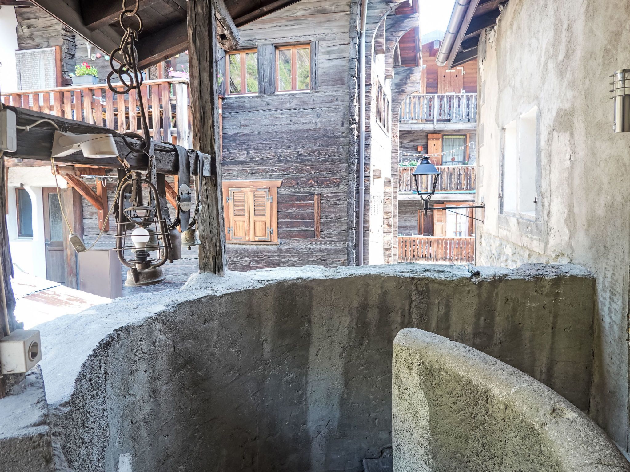 A rustic wooden building with a balcony, a bell, and a lantern.