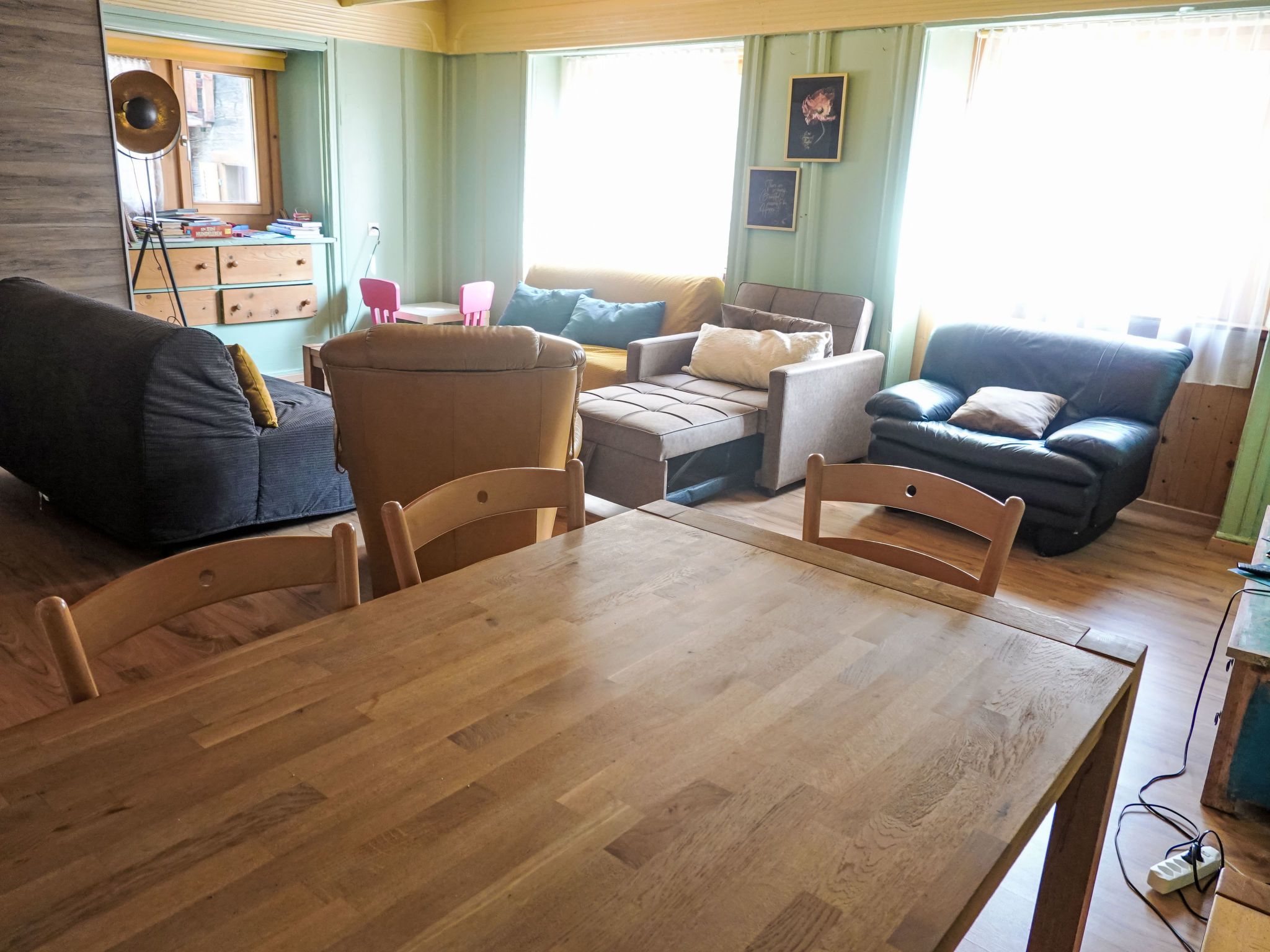 A cozy living room with a wooden dining table, two sofas, and a coffee table.