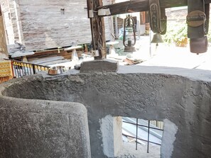 A rustic interior with a concrete structure, a metal railing, and a metal bowl on a rock. - Ferienwohung by Interhome (Belalp-Blatten)