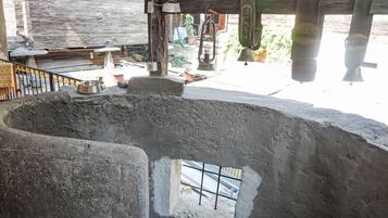 Ein rustikaler Außenbereich mit einer großen Betonkonstruktion, einem Metallgeländer und einem kleinen Fenster.