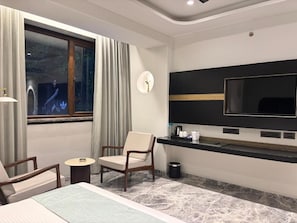 A hotel room with a bed, a TV, a desk, and a chair. - Hotel Midtown (Jamshedpur)