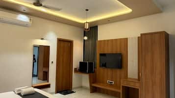 Ein modernes Hotelzimmer mit Bett, Sitzecke, Fernseher und Kleiderschrank.