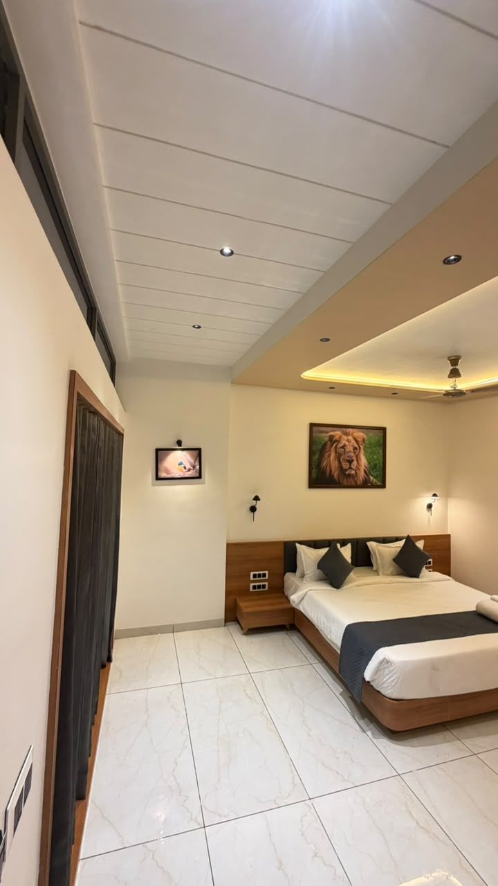 Ein Schlafzimmer mit einem Bett, einem Deckenventilator, Einbauleuchten, einem gerahmten Bild an der Wand und einer Tür.