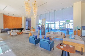 A spacious lobby with a reception desk, seating area, and a view of the parking lot. - Sonoran Star 1106-02 – Seaside Ocean View Paradise (Puerto Peñasco)