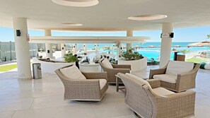 A covered outdoor seating area with wicker furniture and a view of the ocean. - Sonoran Star 1106-02 – Seaside Ocean View Paradise (Puerto Peñasco)