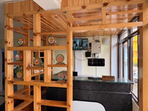 Aula, jossa on puinen vastaanottotiski, lasiseinä ja seinälle kiinnitetty kello.