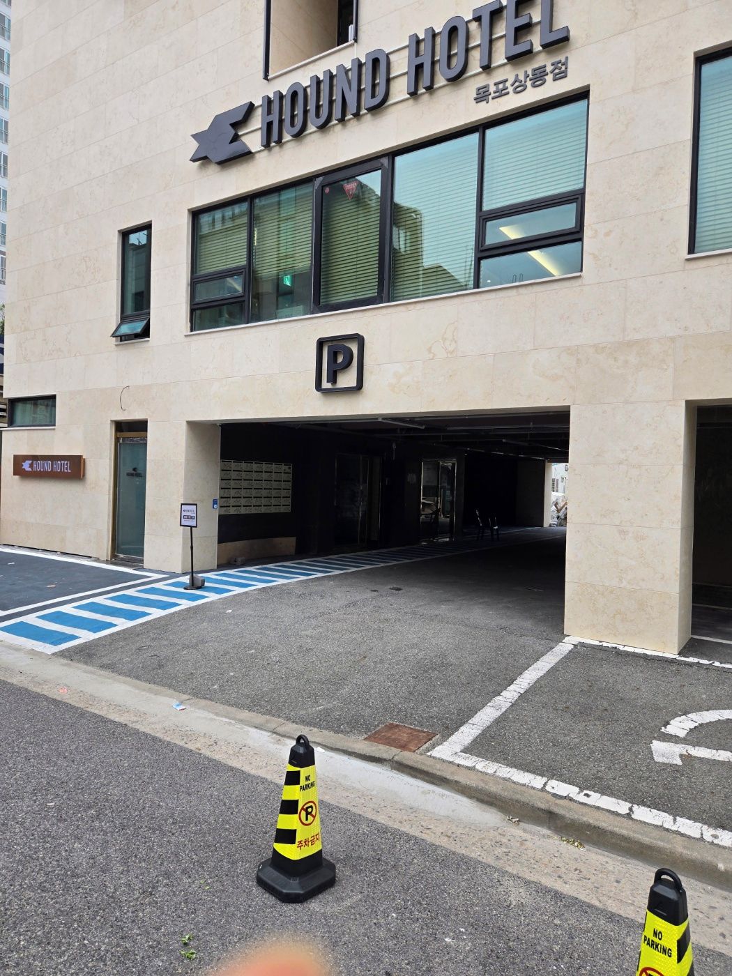A building with a sign reading 'HOUND HOTEL' and a parking sign indicating no parking.