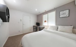 A bedroom with a bed, a desk, a television, and a window. - Hotel AMY (Incheon)