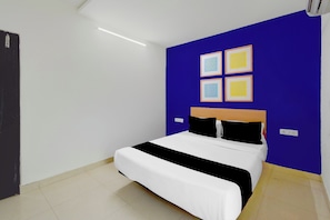 A bedroom with a bed, a blue accent wall, and a door. - Hotel O Netaji Park Hyderabad Formerly (Hyderabad)