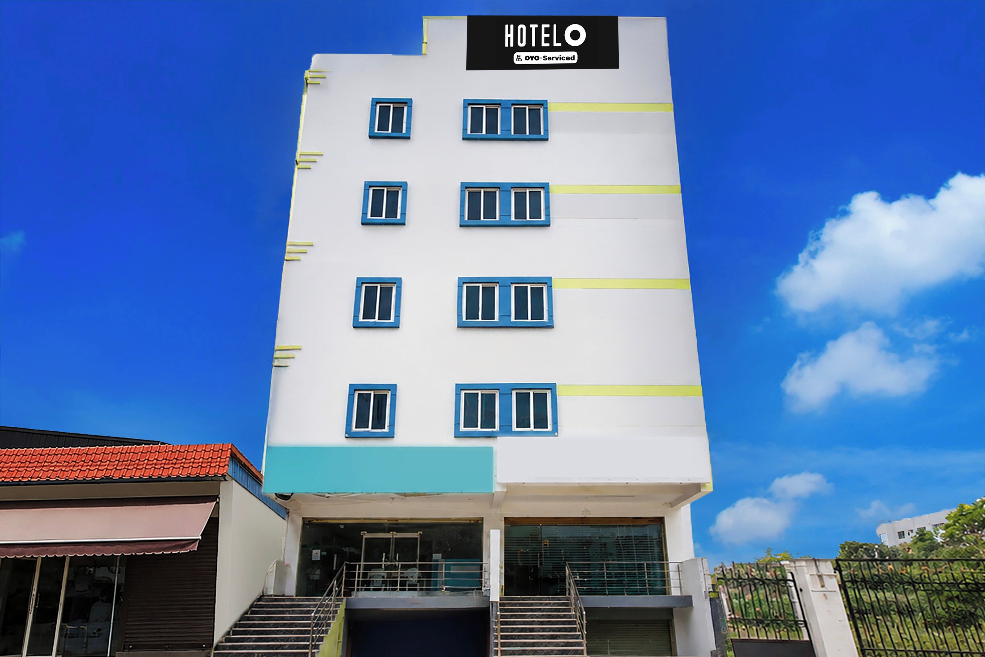 Un edificio de hotel con un cartel que dice 'HOTEL OYO-Serviced' y varias ventanas.