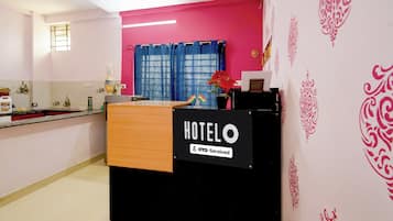 A hotel reception desk with a sign indicating it is serviced by OYO.