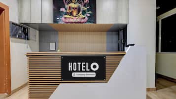A hotel reception desk with a 'HOTELO' sign and a 'Company-Serviced' label.