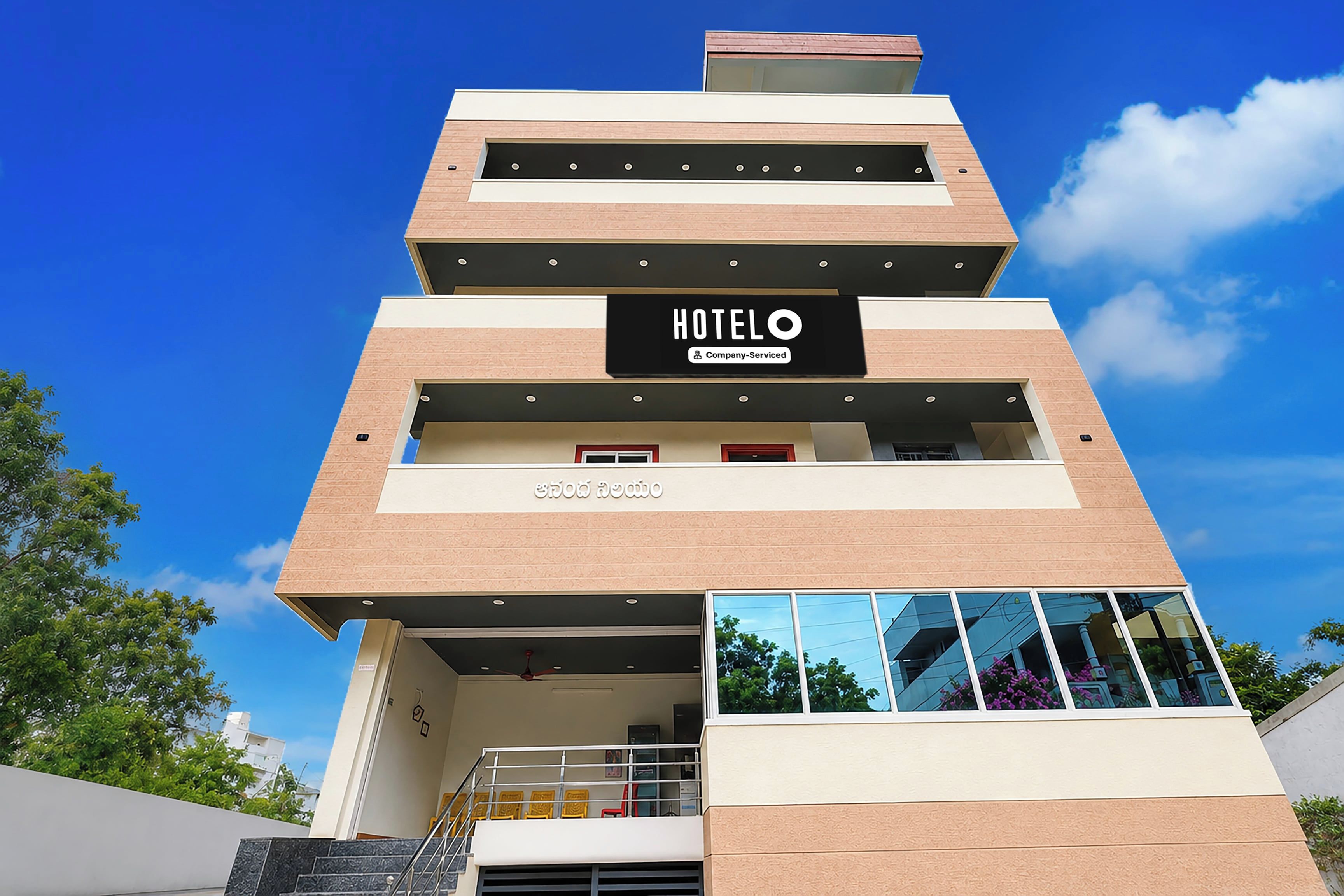 Een hotel met meerdere verdiepingen, modern van ontwerp, met een opvallend 'HOTEL'-bord op de gevel.