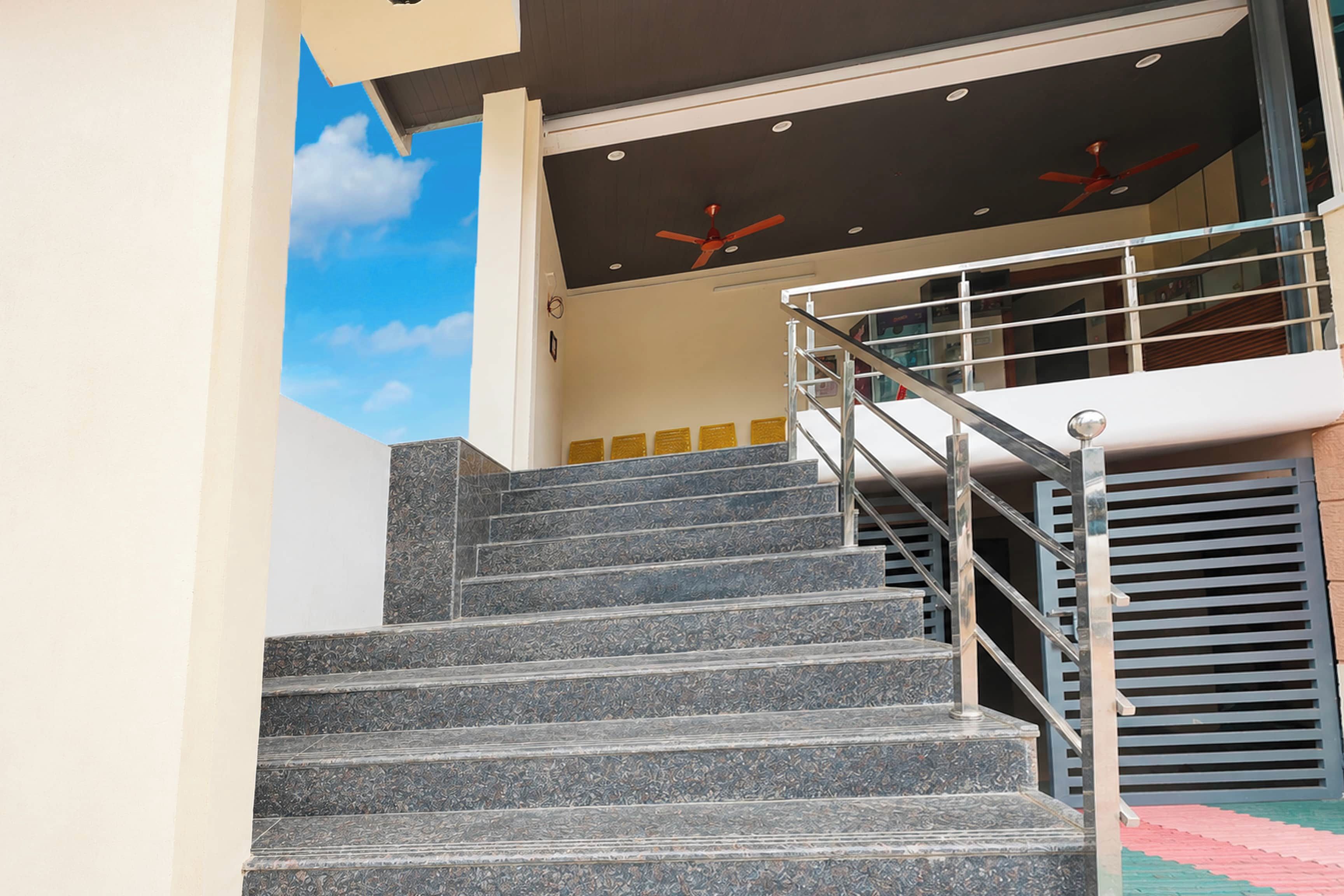 A staircase with metal railings leading to a landing with a ceiling fan.