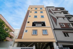 Un edificio de varios pisos con un letrero que dice 'TOWNHOUSE' y 'OYO-Serviced'.