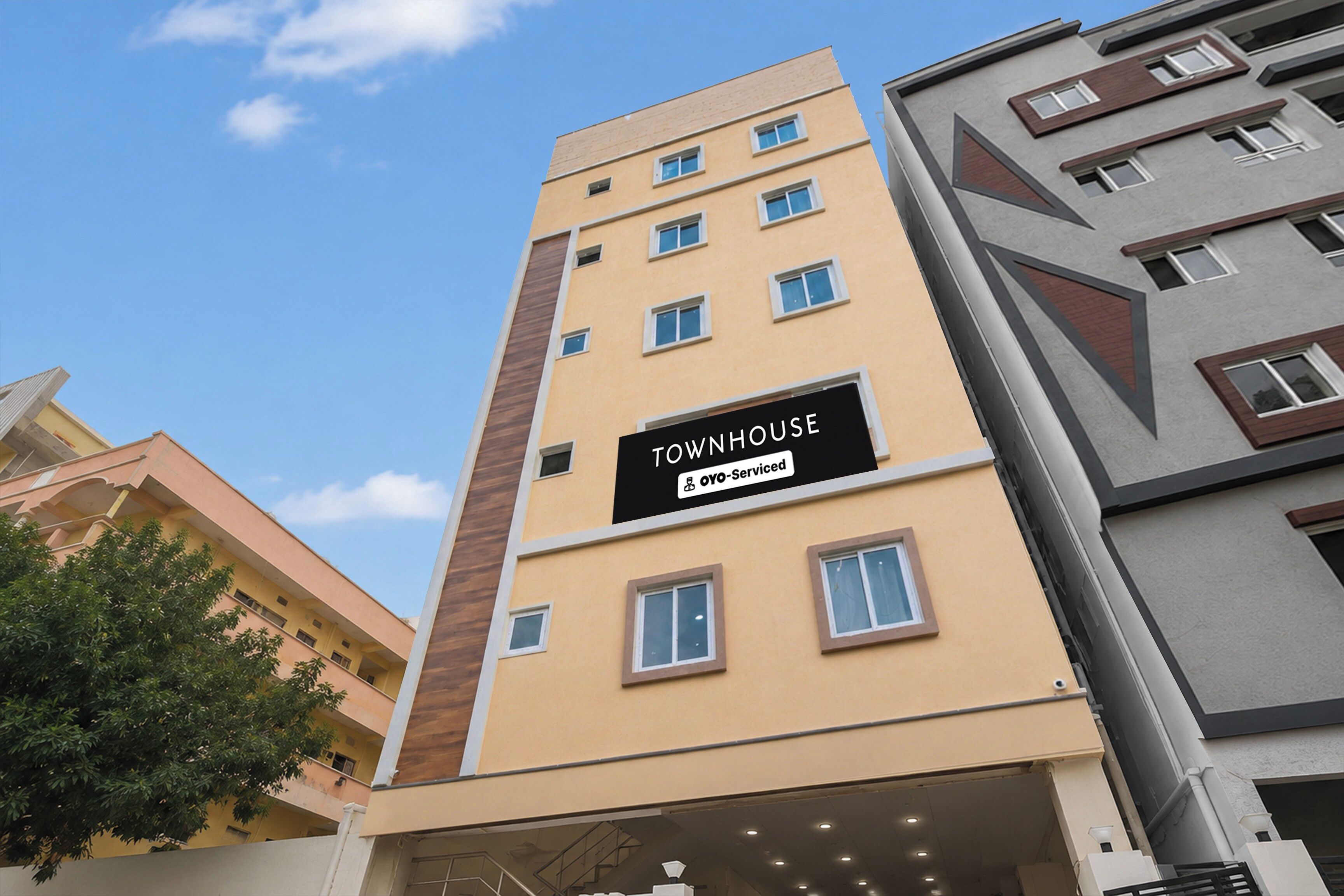 A multi-story building with a sign indicating it is serviced by OYO.
