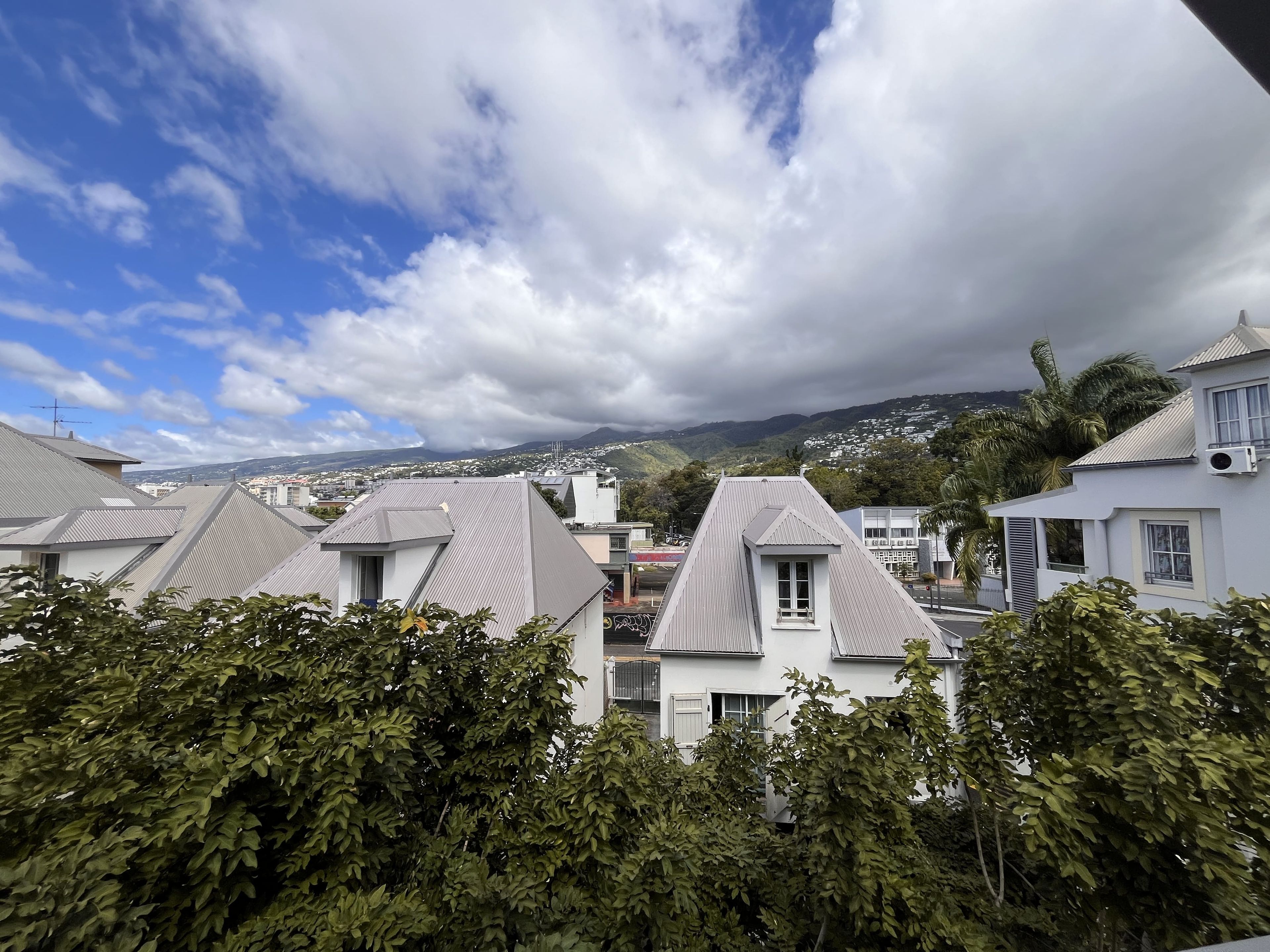 Zona residencial con casas, cielo despejado y montañas a lo lejos.