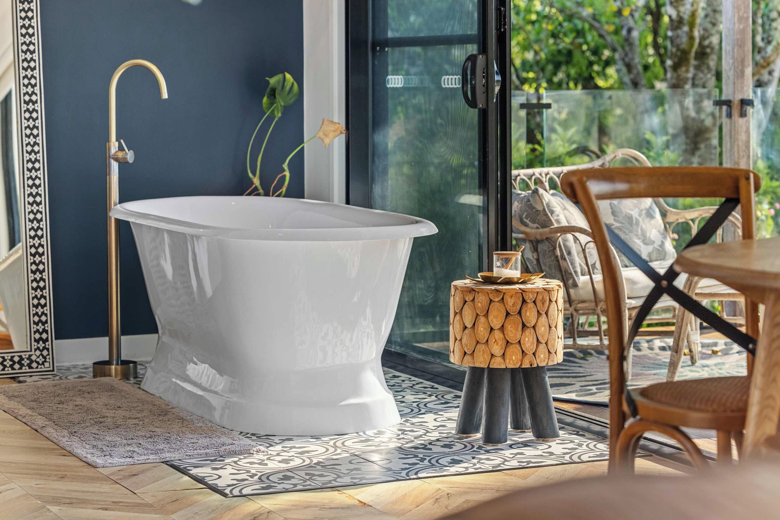 Ein modernes Badezimmer mit einer freistehenden Badewanne, einem Holztisch und einem Stuhl.