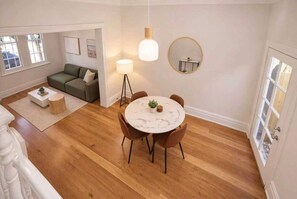 Ett modernt vardagsrum med ett runt matbord, en soffa och en golvlampa.