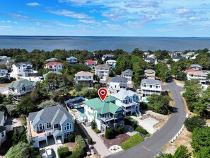 A residential area with houses, a road, and a body of water in the background. - Soundside- Private Pool, Comm Amenities-MS842, Bella Vita OBX (Corolla)