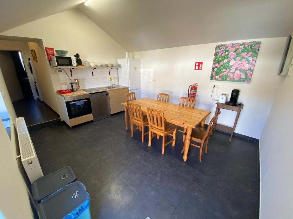 A kitchen with a dining table and chairs, a microwave, and a fire extinguisher.