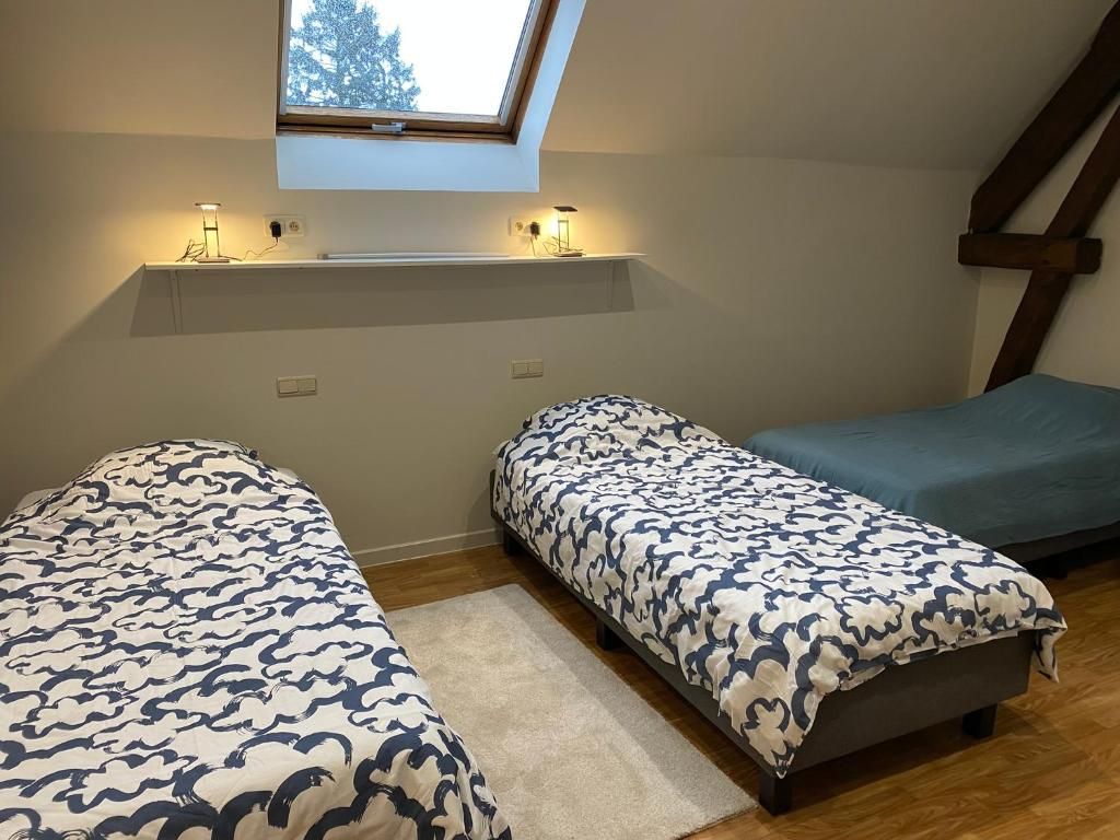 Makuuhuoneessa on kaksi sänkyä, kattovalokuvio ja hylly, jossa on valot.