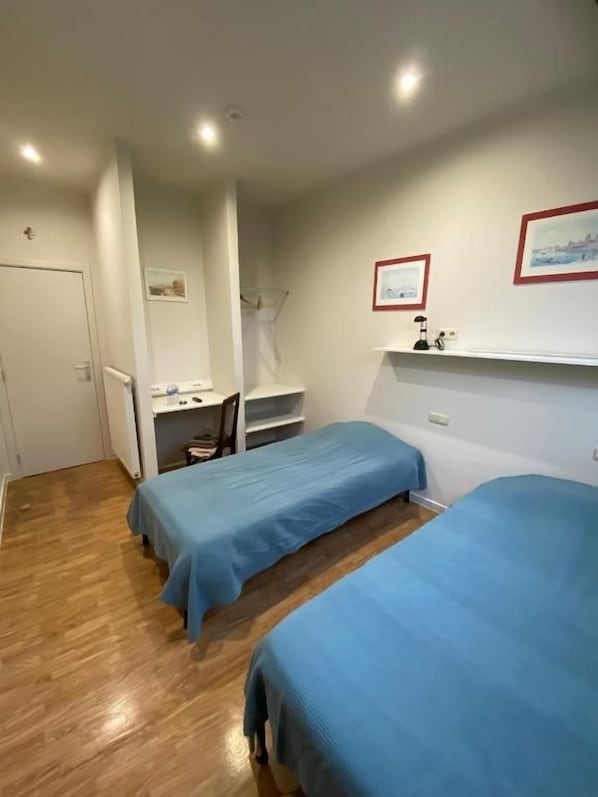 Une chambre avec deux lits, un bureau et une chaise.