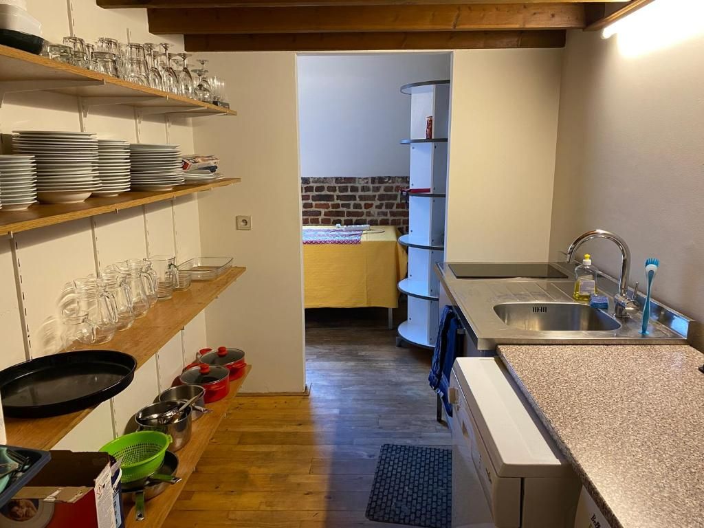 Una cocina con estantes de madera, un lavamanos y una encimera.
