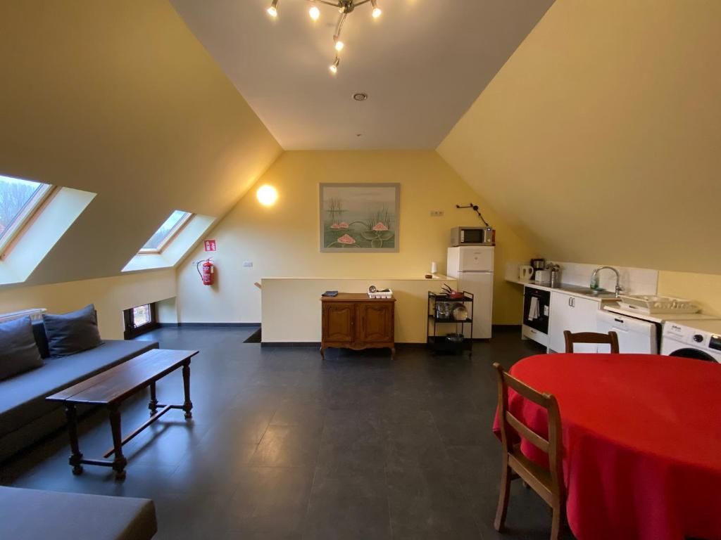 A compact living space with a kitchenette, a dining area, a sofa, and a bench.