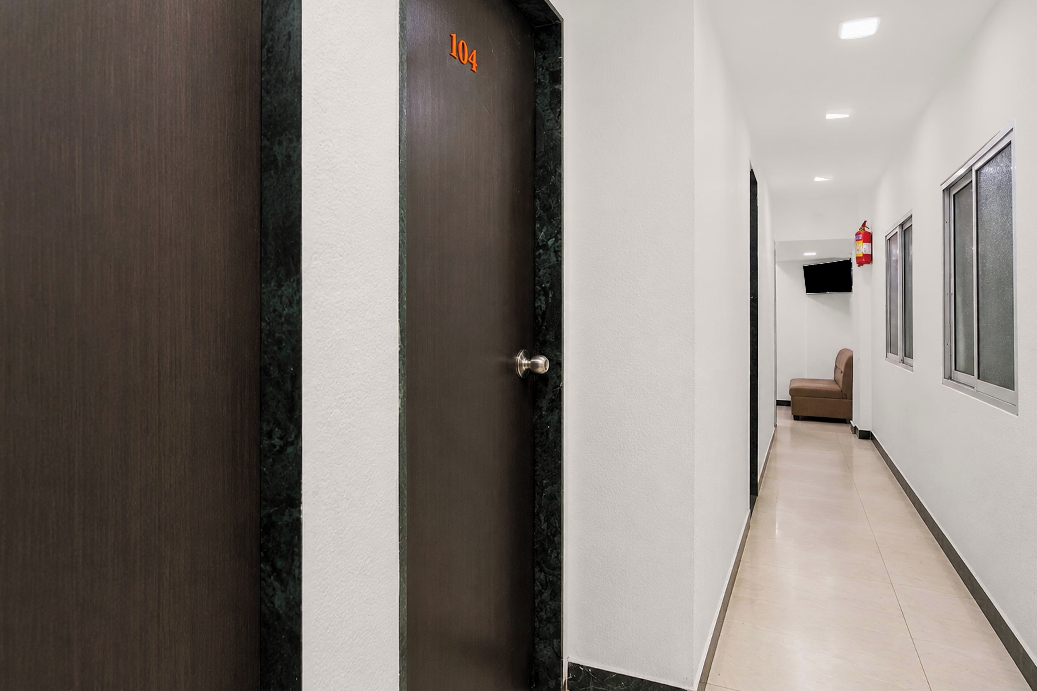 A hallway with a door marked '104' and a fire extinguisher on the wall.
