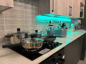 A modern kitchen with a gas stove, pots, a kettle, and a toaster. - Cozy Retreat in Carlswald 264 (Johannesburg)