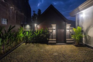 A building with a dark facade, a sign reading 'EMY KEROBOKAN', and a well-lit entrance. - Emy Kerobokan (Badung)