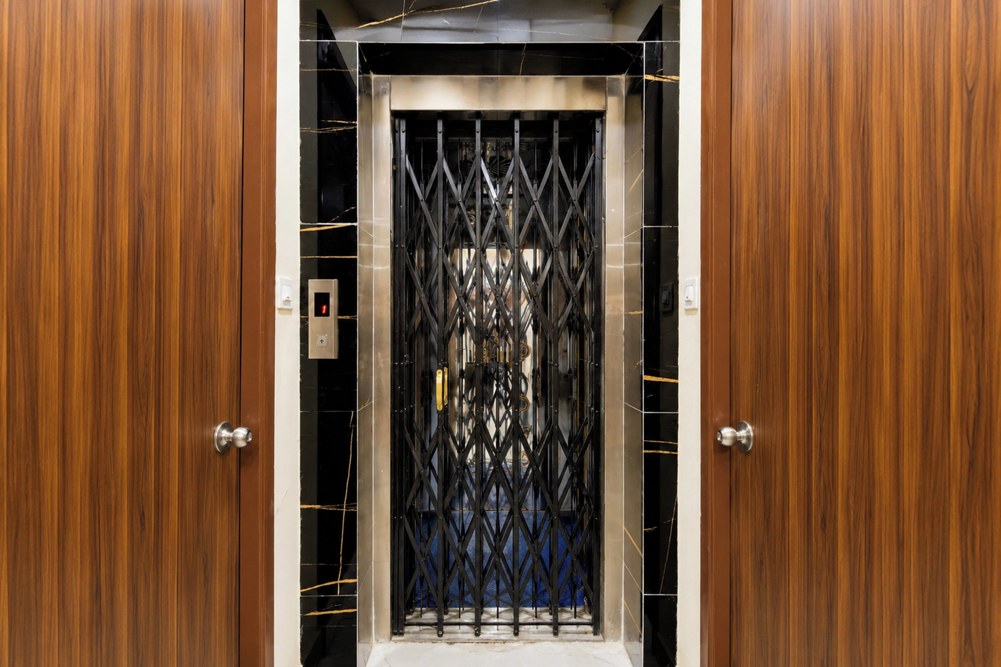 An elevator with a metal gate and wooden doors.