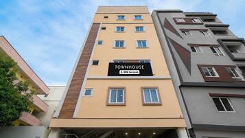 A multi-story building with a sign reading 'TOWNHOUSE' and 'OYO-Serviced'.