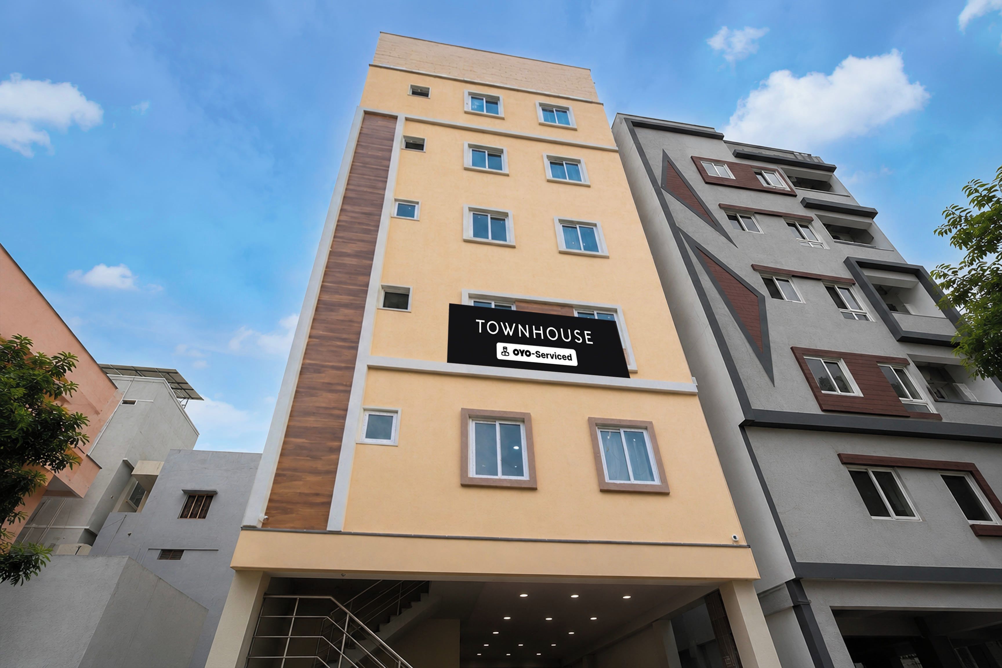 Un edificio de varios pisos con un letrero que dice 'TOWNHOUSE' y 'YO-Serviced'.
