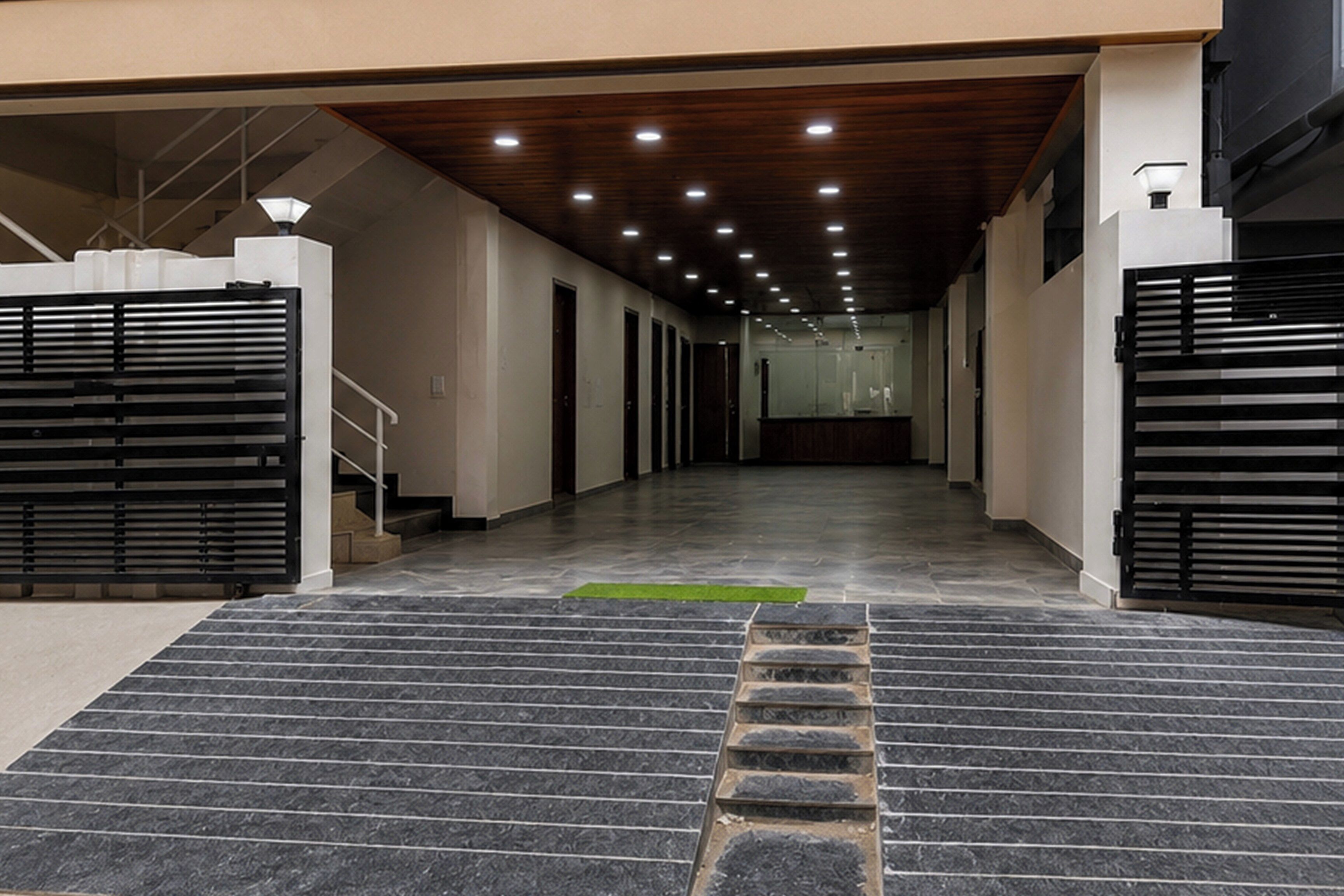 Entrada moderna de um edifício com escadaria que leva a uma área cercada.
