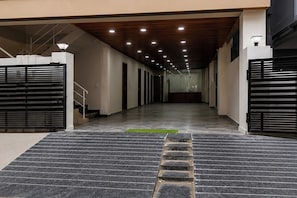A modern building entrance with a staircase leading up to a gated area. - Collection O Deepor Beel (Guwahati)