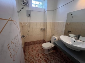 Un baño con inodoro, lavabo y ducha.